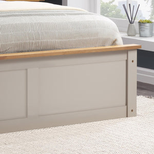 Bed with wooden headboard and striped bedding in a bedroom setting.
