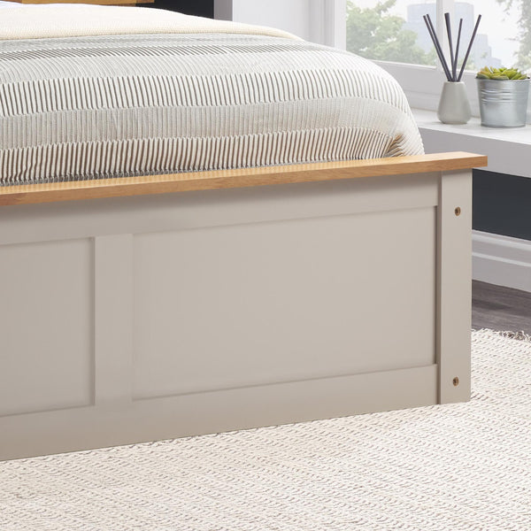 Bed with wooden headboard and striped bedding in a bedroom setting.