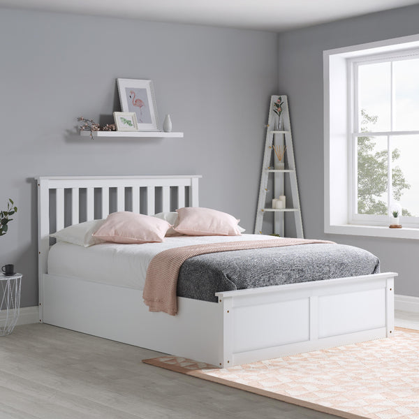 White bed in a bedroom with gray walls and a window.