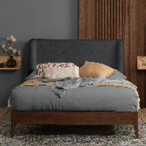 Bedroom with a bed featuring gray bedding and wooden headboard against a dark gray wall.