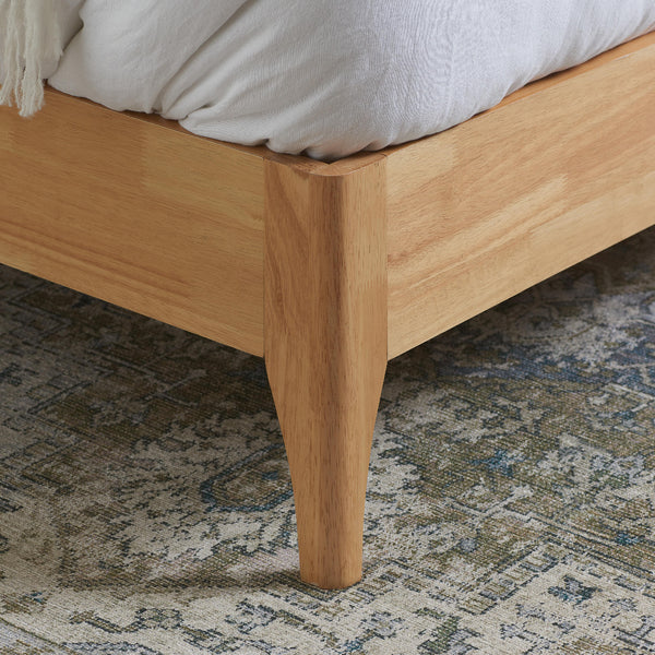 Wooden bed frame on a patterned rug