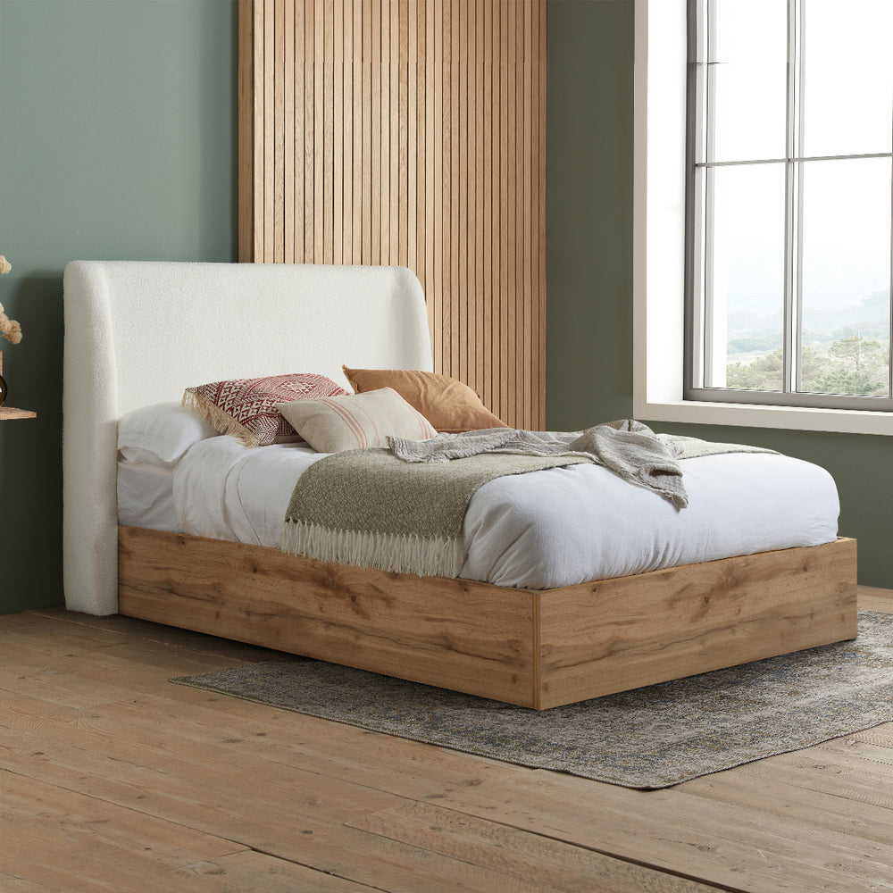 Bed with white upholstered headboard and wooden frame on a white background
