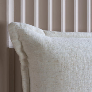 Close-up of a textured white pillow against a neutral background