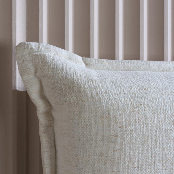 Close-up of a textured white pillow against a neutral background