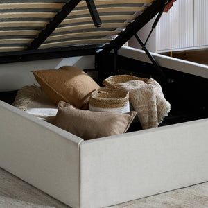 Beige bed with striped canopy and decorative pillows and baskets.