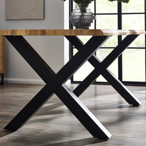 Dining table with black X-shaped legs in a room with large windows.