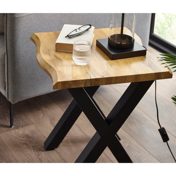 Wooden side table with black metal legs in a room setting