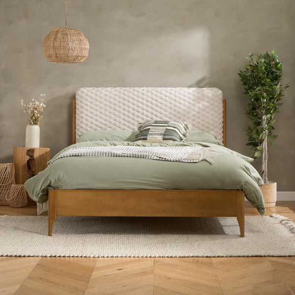 Bedroom with wooden bed, green bedding, and decorative elements.