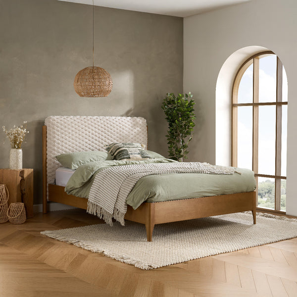 Bedroom with wooden bed, green bedding, and large window
