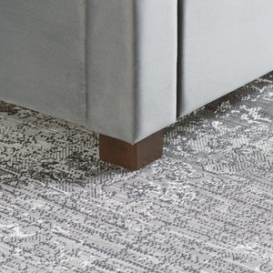 Close up of small wooden foot on grey bed frame
