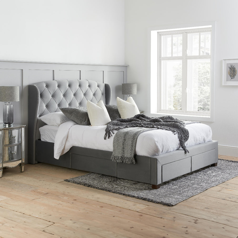 Gray upholstered bed with tufted headboard on a white background