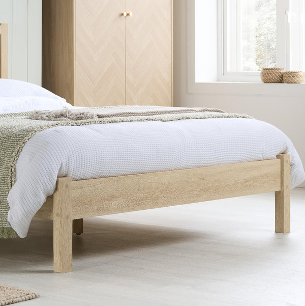 Wooden bed with white bedding in a bedroom setting
