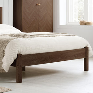 Wooden bed with white bedding in a bedroom setting