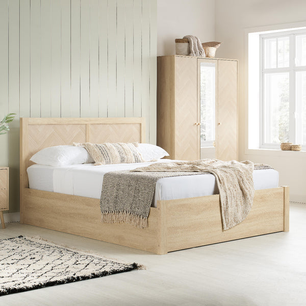 Wooden bed with white bedding and a matching wardrobe in a bright bedroom.