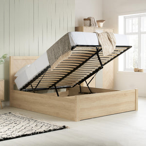 Wooden bed frame with storage compartment in a bright bedroom.