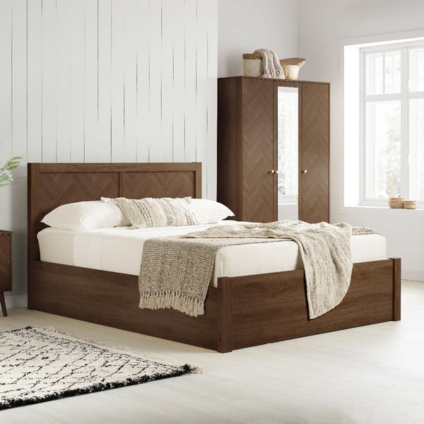 Wooden bed with white bedding and a matching wardrobe in a bright bedroom.