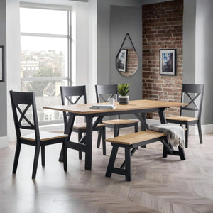 Dining room with wooden table and chairs against a brick wall.