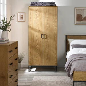 Wooden wardrobe in a bedroom with a bed and dresser.