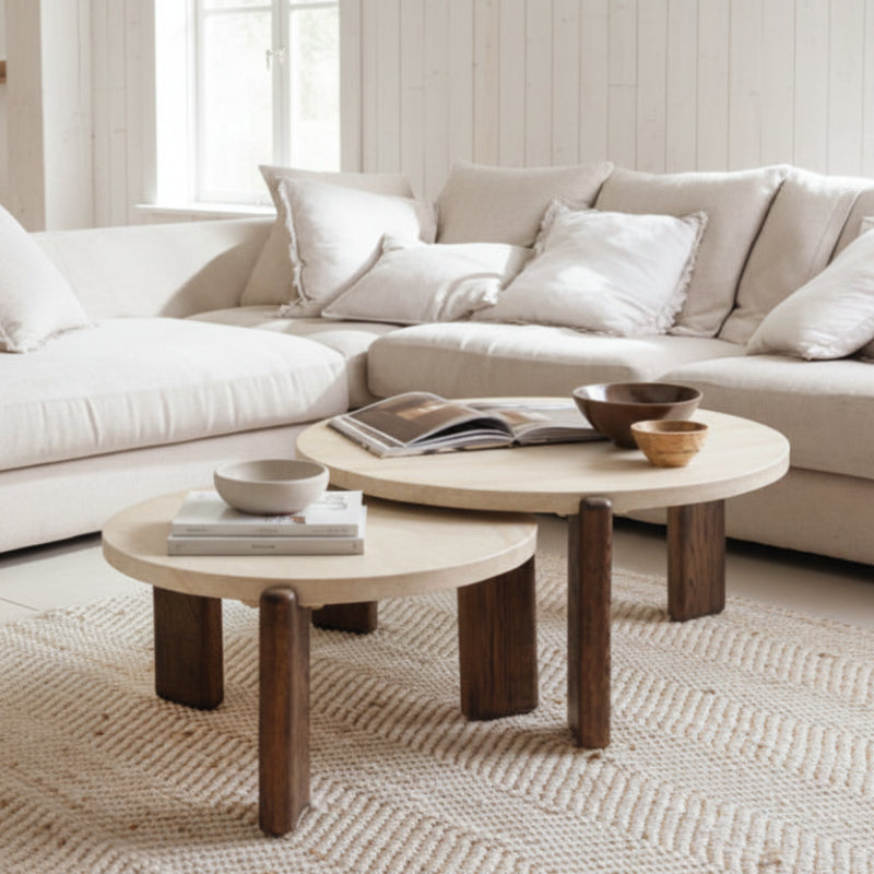 Round wooden table with light beige top and dark brown legs on a white background