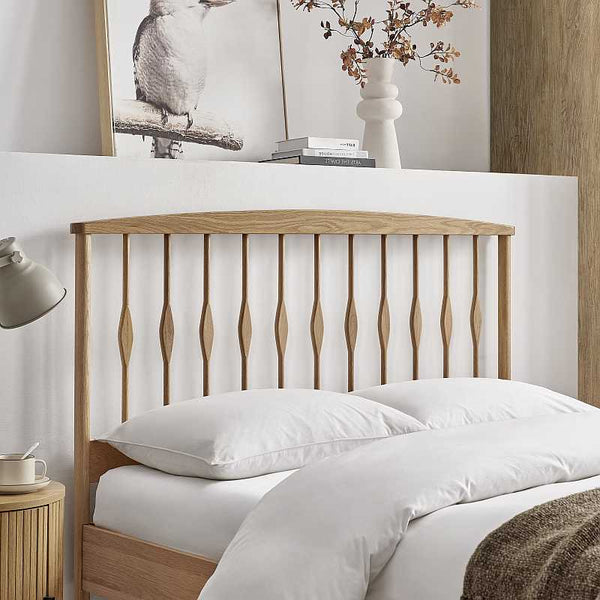 Wooden headboard with white bedding and decor in a bedroom setting