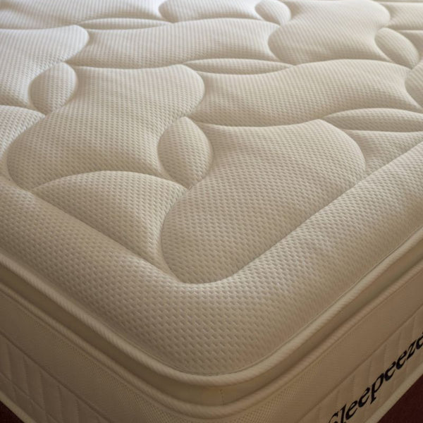 Close-up of a mattress with 'Sleepeezee' branding in a bedroom setting.