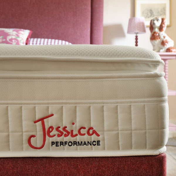 Beige mattress with 'Jessica Performance' branding in a bedroom setting.