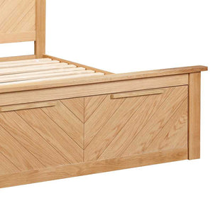 Wooden bed frame with a chevron pattern on a white background