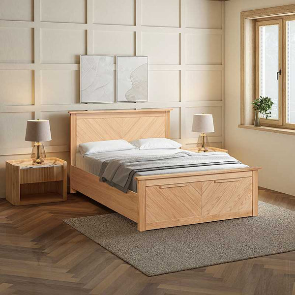 Wooden bed with matching nightstands and lamps in a bedroom setting.