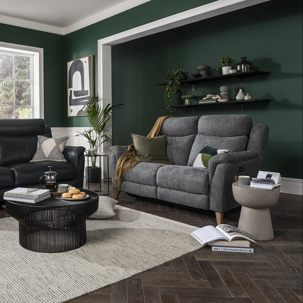Living room with dark green walls, gray sofa, and black coffee table.