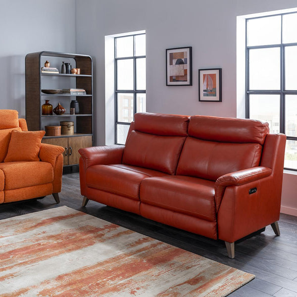 Living room with orange and red sofas, a rug, and decorative items.