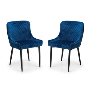 Two blue velvet chairs with black legs on a white background