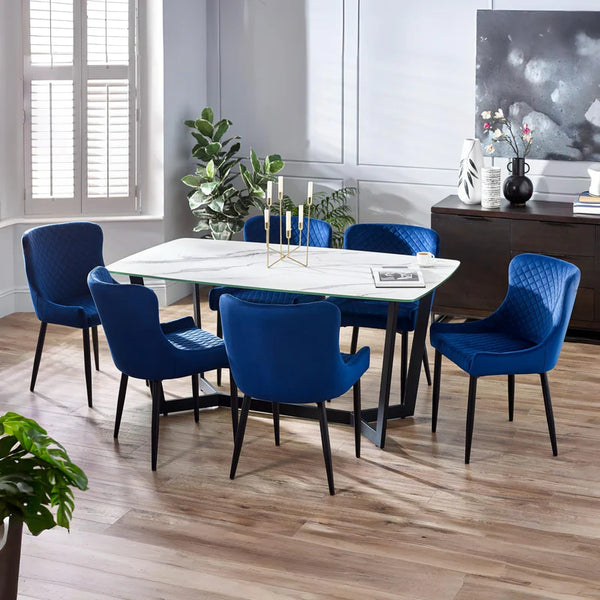 Dining room with a white table and blue chairs in a modern interior setting.