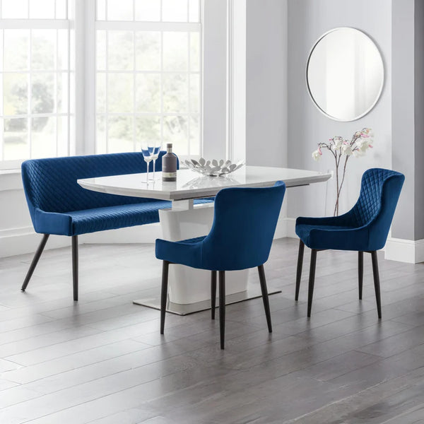 Modern dining set with blue chairs and bench around a white table in a bright room.