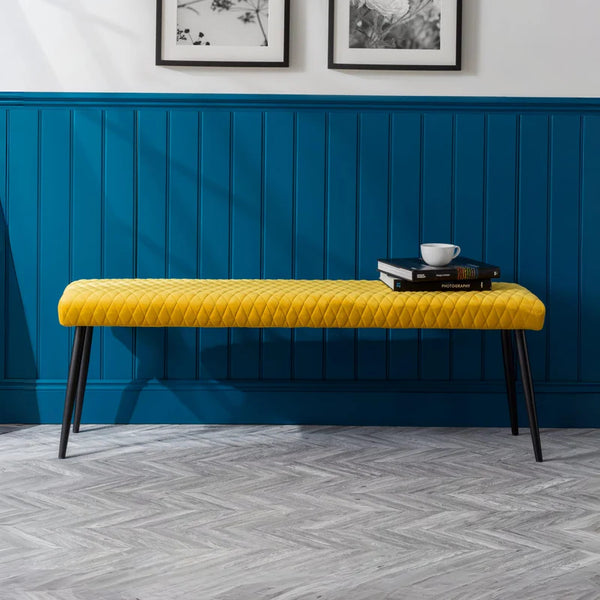 Yellow bench against a blue paneled wall with decorative elements.