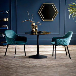 Modern interior with two teal chairs around a black table against a blue wall.