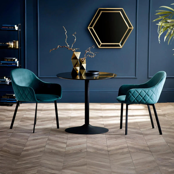 Modern interior with two teal chairs around a black table against a blue wall.