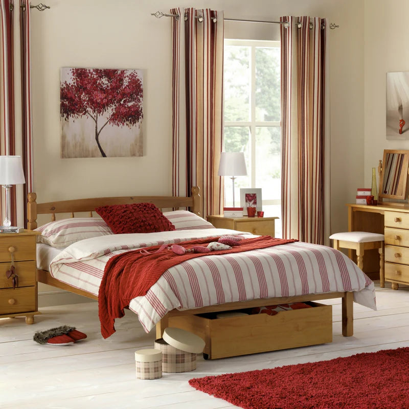 Wooden bed with red and white striped bedding on a white background