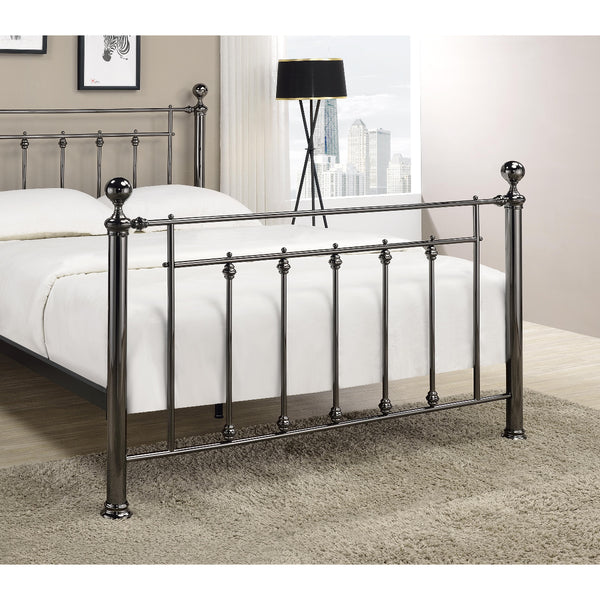 Metal bed frame with white bedding in a room with a lamp and window.