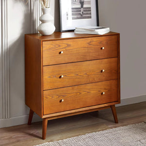 Wooden dresser with three drawers in a room setting