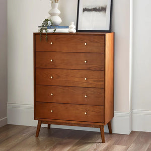 Wooden dresser with five drawers in a room setting.