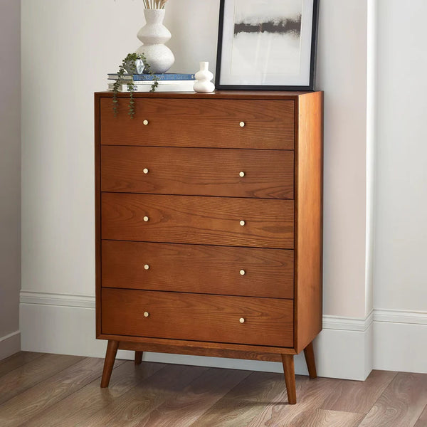 Wooden dresser with five drawers in a room setting.