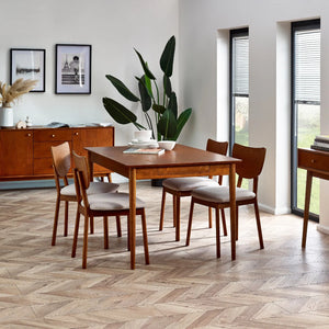 Dining room with wooden table and chairs on a herringbone floor.