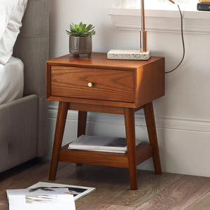 Wooden nightstand with a plant and books in a bedroom setting