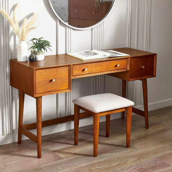 Wooden vanity desk with mirror, stool, and decorative items in a room.