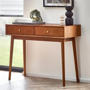 Wooden console table with two drawers in a room with a window and decor items.