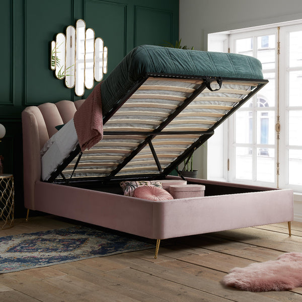 Pink bed with storage compartment in a room with green walls and large windows.