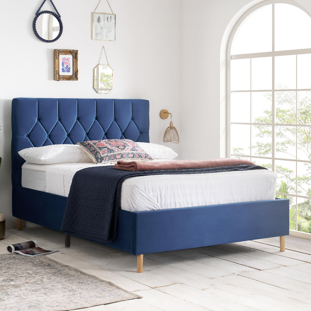 Blue bed frame with mattress on a white background