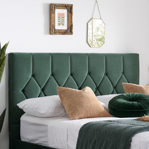 Green tufted headboard with decorative pillows in a bedroom setting.