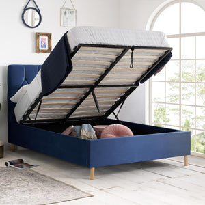 Blue bed with open storage compartment in a bright room