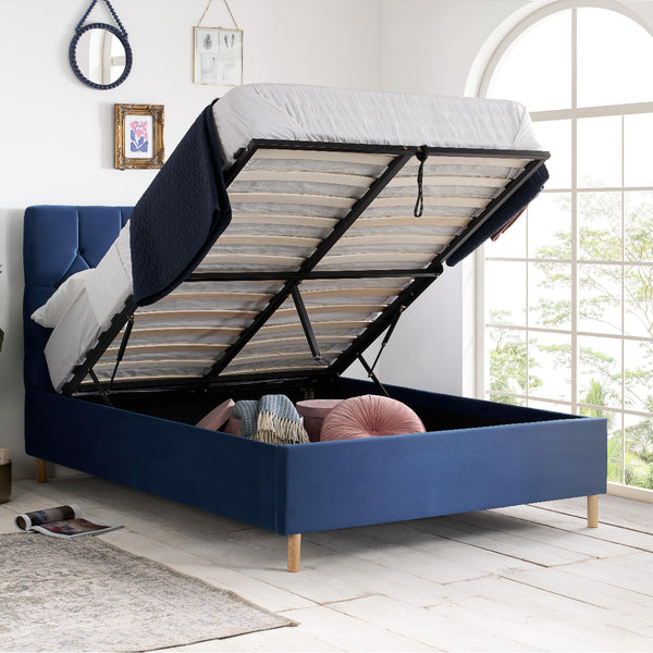 Blue bed with open storage compartment in a bright room